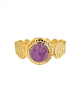 Goldener Ring mit gehämmerter Struktur, in der Mitte ist ein lila Stein